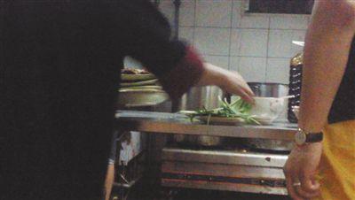 7月23日,漢麗軒烤肉超市昌平店,服務員將幾盤顧客剩菜(左手中疊在一起的是幾盤肉,其右手正整理韭菜)端回后廚,進行整理后準備再送往餐廳自助取餐區(qū)供顧客食用。